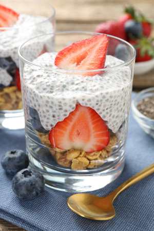 Delicious dessert with chia seeds, yogurt, granola, strawberries and blueberries on table, closeup. Superfoodの写真素材