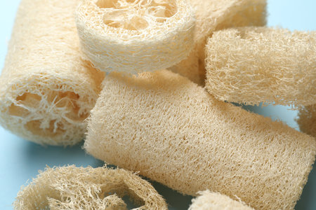 Natural loofah sponges on light blue background, closeupの写真素材
