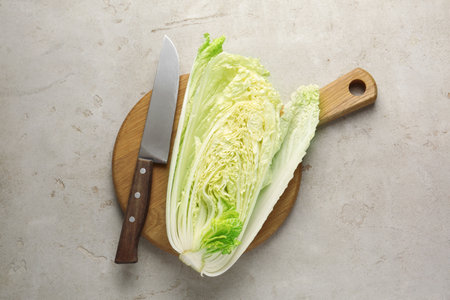 Cut Chinese cabbage and knife on light grey table, top viewの写真素材