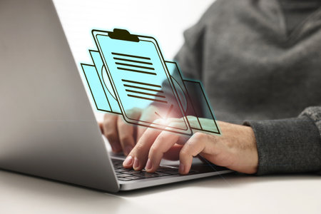 Human resources manager working on laptop at table, closeup. Candidate's resume on virtual screen above computer. Recruitment and employee searchの写真素材