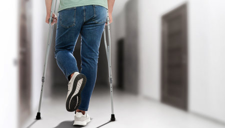 Man with axillary crutches in hospital, closeup. Banner designの写真素材