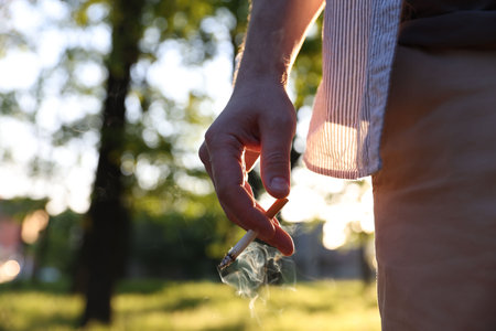Man with cigarette in park, closeup. Space for textの写真素材