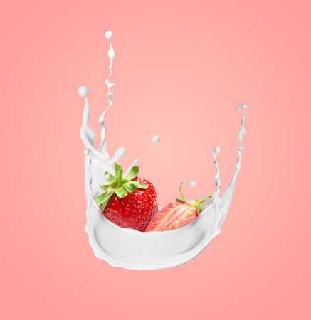 Fresh juicy strawberries in cream splash on pink backgroundの写真素材