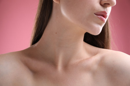 Woman with beautiful collarbones and neck on pink background, closeupの写真素材