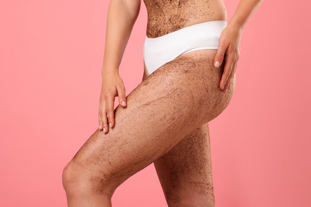 Woman with body scrub on her skin against pink background, closeupの写真素材