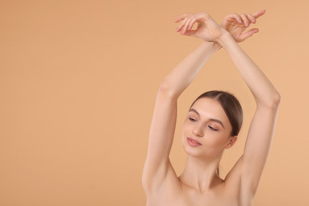 Young woman showing smooth skin after epilation on beige background, space for textの写真素材