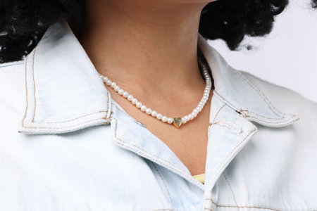 Young woman wearing elegant pearl necklace on white background, closeupの写真素材