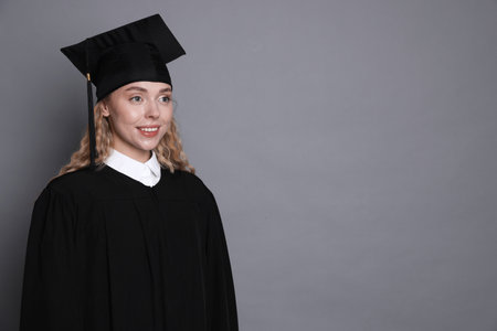 Happy student after graduation on grey background. Space for textの写真素材