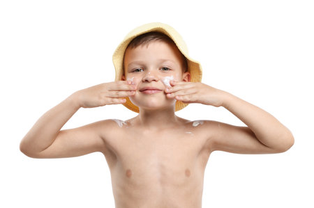 Little boy applying sun protection cream onto his skin on white backgroundの写真素材