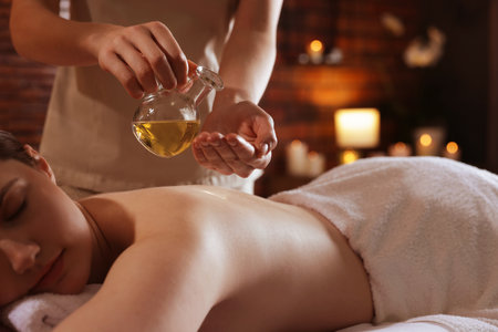 Woman receiving back massage with oil in spa salon, closeupの写真素材