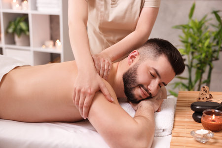 Man receiving relaxing massage in spa salonの写真素材