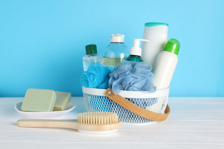 Different bath accessories on white wooden table against light blue background, closeupの写真素材