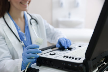 Professional sonographer with ultrasound machine in clinic, closeup
