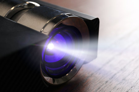 Modern video projector working on wooden table indoors, closeupの写真素材
