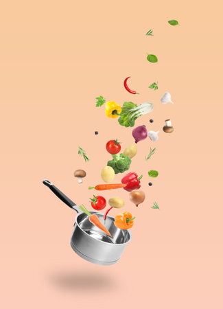 Fresh vegetables and saucepan in air against pink beige backgroundの写真素材