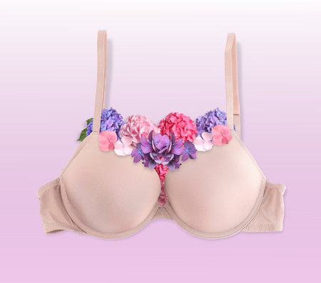 Beautiful beige bra with hydrangea flowers on gradient background, top viewの写真素材