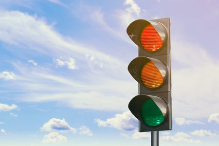 Traffic lights against blue sky with clouds