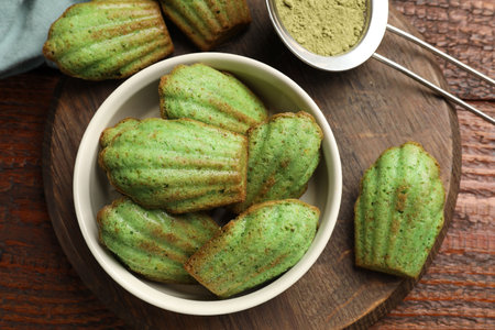 Tasty matcha madeleine cakes on wooden table, top view