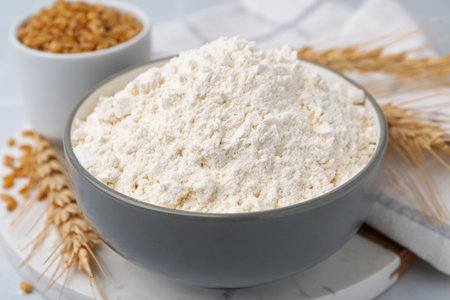 Wheat flour, grain and spikes on white table, closeupの写真素材