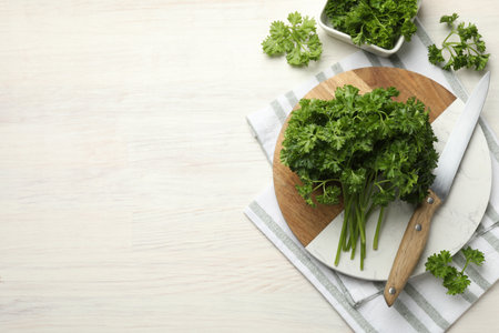 Fresh parsley and knife on light wooden table, flat lay. Space for textの写真素材