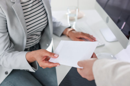 Money bonus. Employee receiving envelope from boss in office, closeupの写真素材