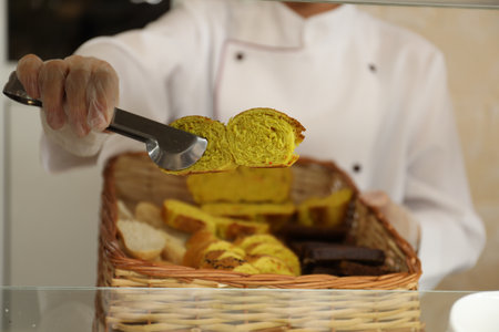 School canteen worker with basket of bread at serving line, closeup. Tasty foodの写真素材