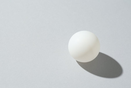 One ping pong ball on light background. Space for textの写真素材