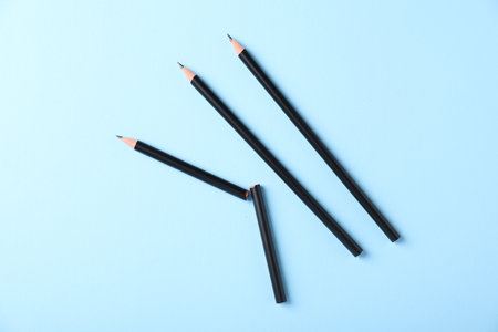 Many sharp graphite pencils on light blue background, flat layの写真素材