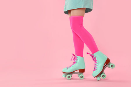 Woman in roller skates on pink background, closeup. Space for textの写真素材
