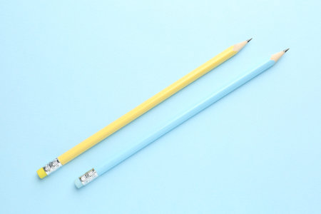Two graphite pencils on light blue background, flat layの写真素材
