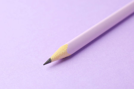 One graphite pencil on violet background, closeup