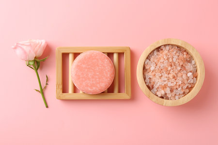 Soap bar, sea salt and beautiful rose on pink background, flat layの写真素材