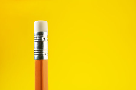 One pencil with eraser on yellow background, closeup. Space for text