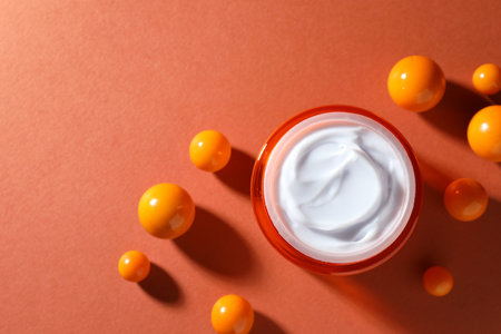 Jar of moisturizing body cream and balls on orange background, flat lay. Space for textの写真素材