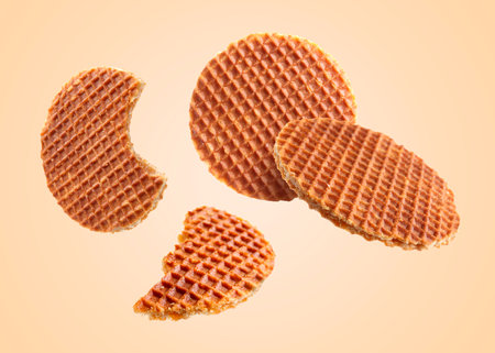 Yummy Dutch waffles (stroopwafels) flying on beige backgroundの写真素材