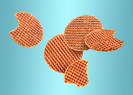 Yummy Dutch waffles (stroopwafels) flying on light blue gradient backgroundの写真素材