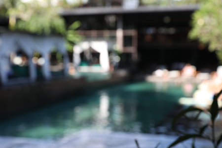 Blurred view of sunbeds and swimming pool outdoors