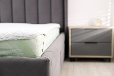 Comfortable bed with new soft mattress indoors, closeupの写真素材