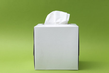 Box with paper handkerchiefs on green backgroundの写真素材
