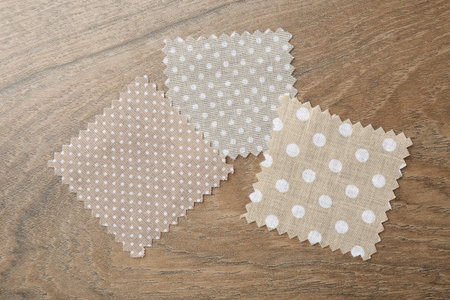 Samples of different fabrics on wooden table, flat lay