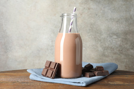 Chocolate milk in glass bottle and ingredient on wooden tableの写真素材