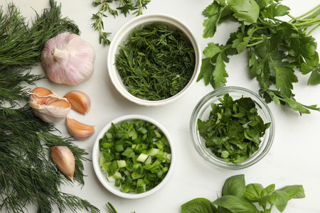 Different herbs and spices on white table, flat lay
