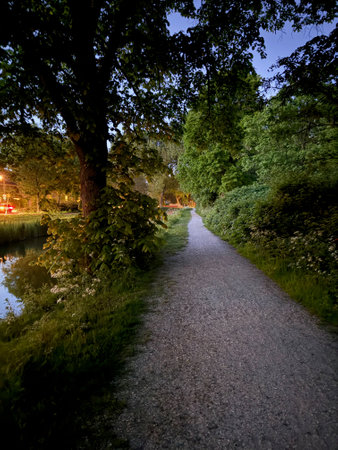 Picturesque view of canal, pathway and trees in parkの写真素材