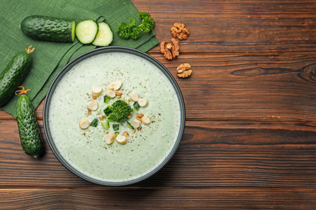 Tasty cucumber soup with croutons and broccoli on wooden table, flat lay. Space for textの写真素材