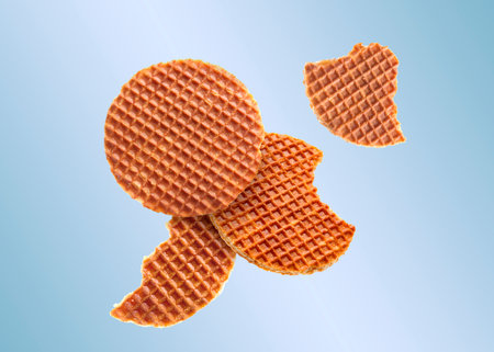 Yummy Dutch waffles (stroopwafels) flying on light blue gradient backgroundの写真素材