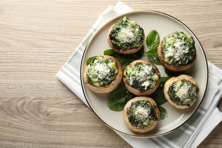 Tasty stuffed mushrooms served on light wooden table, top view. Space for textの写真素材