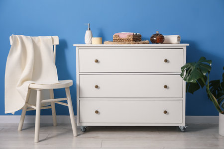 Clean waffle towel on chair and dresser near blue wallの写真素材