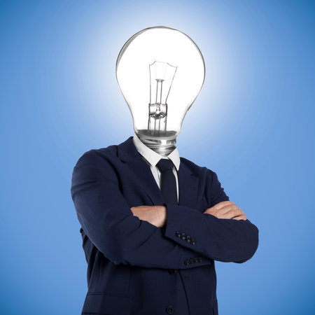 Man with glowing lightbulb instead of head on light blue backgroundの写真素材