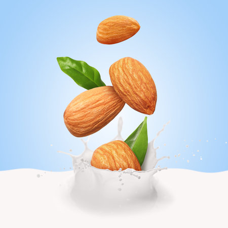 Almonds falling into splashing nut milk against light blue backgroundの写真素材