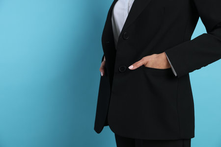 Confident business woman in suit on light blue background, closeup. Space for textの写真素材